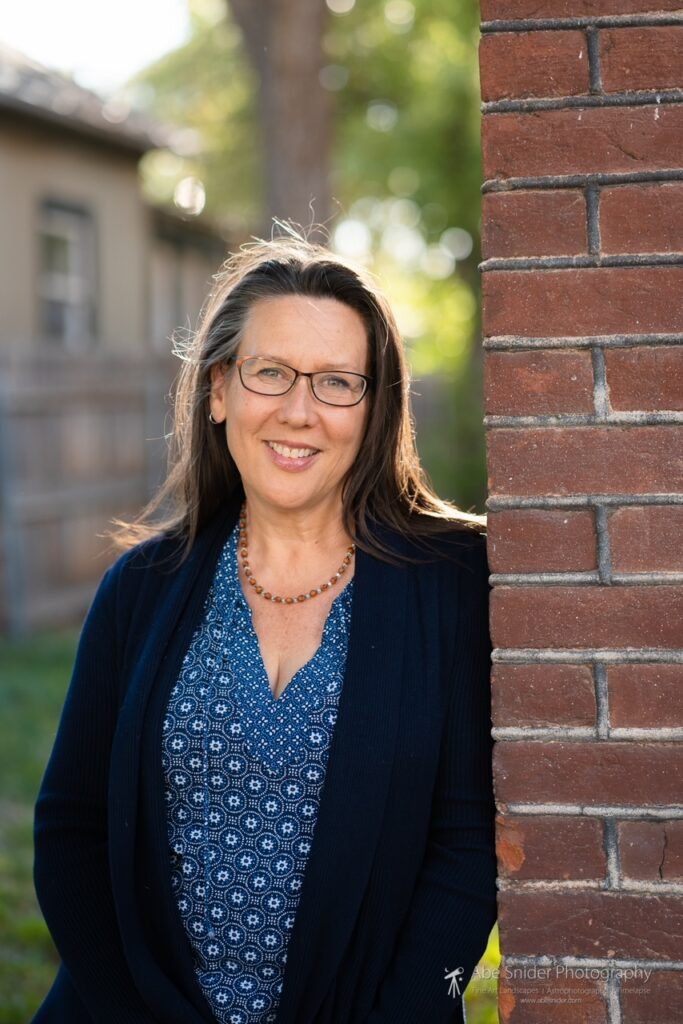 Aileen Judson smiling beside a brick wall